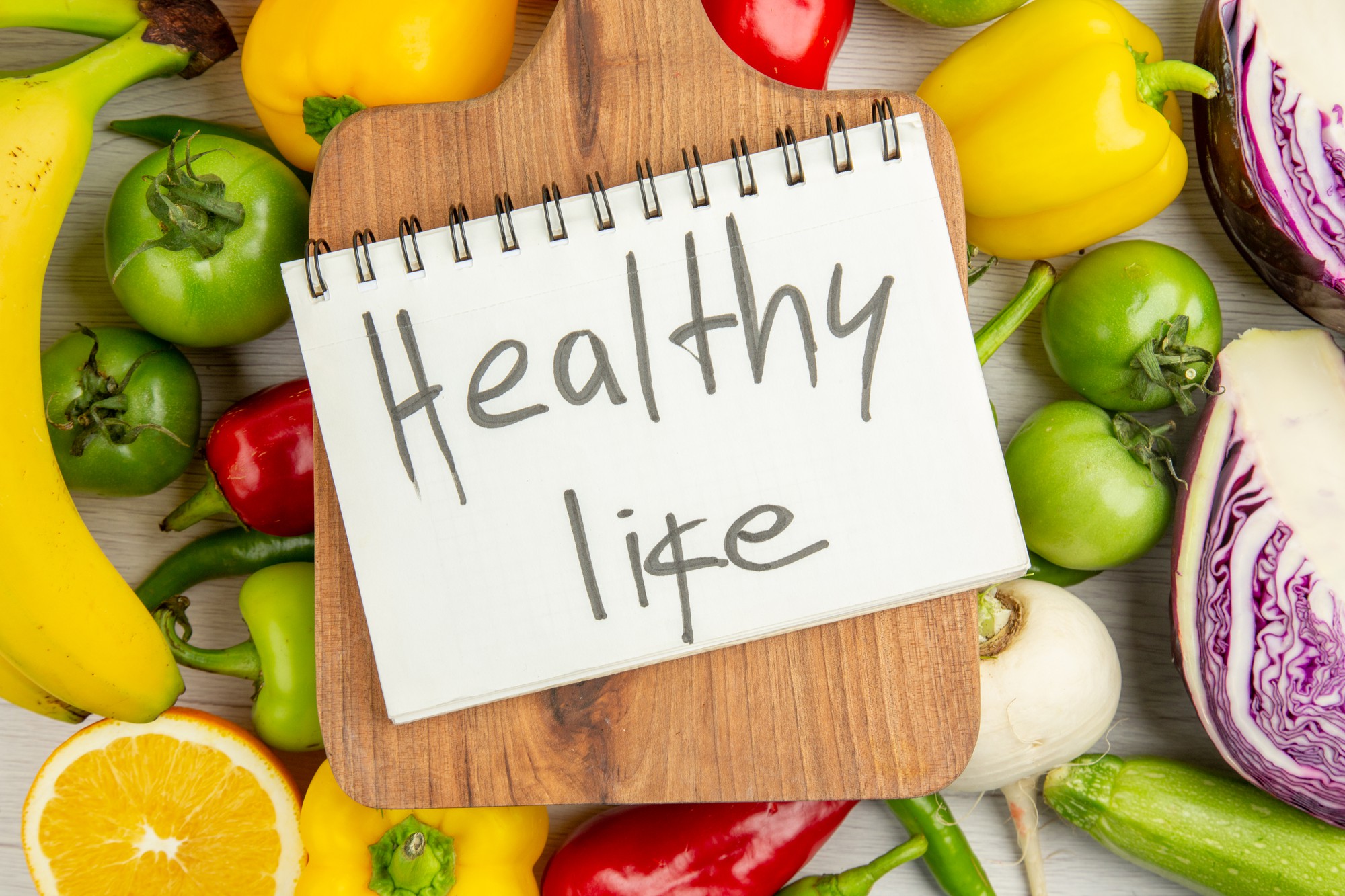 top-view-fresh-bell-peppers-with-greens-bananas-red-cabbage-white-background-diet-ripe-color-healthy-life-salad-photo