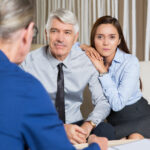 Business Partners and Daughter Talking at Table