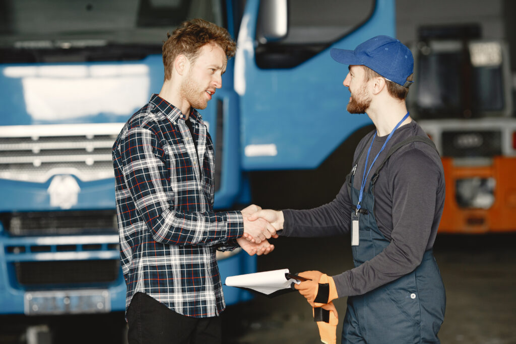 Two young men discuss work issues in garage