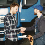 Two young men discuss work issues in garage