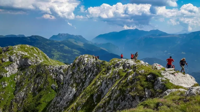 Hikers walking along a rocky mountain ridge in the Balkan Mountains with panoramic valley views
