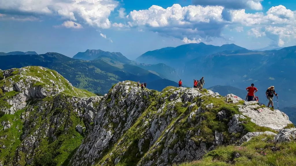 Hikers walking along a rocky mountain ridge in the Balkan Mountains with panoramic valley views