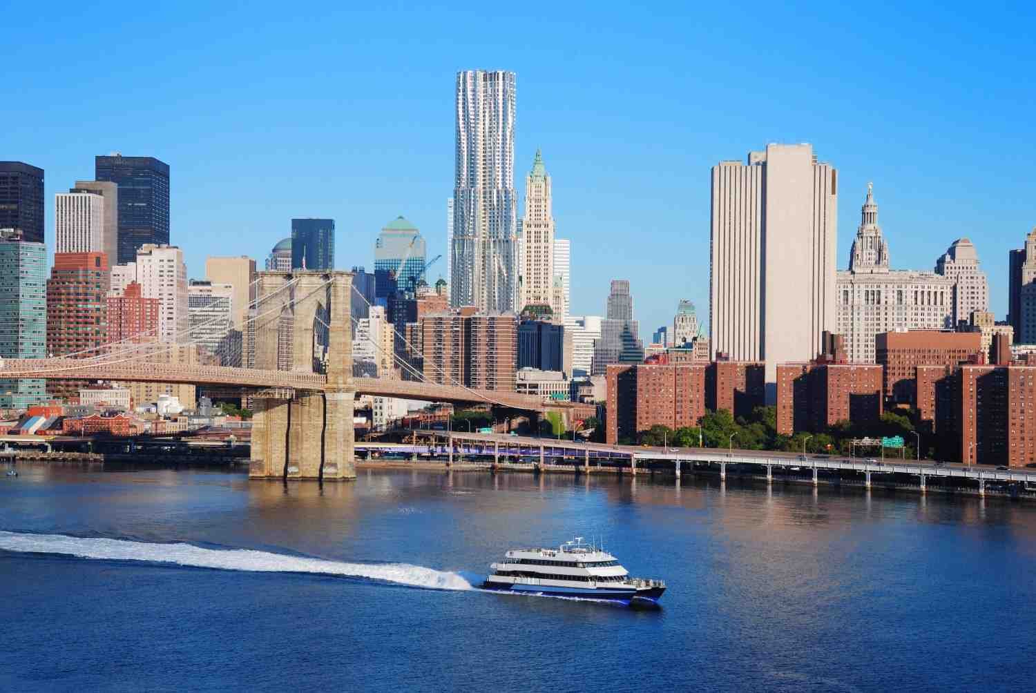 Manhattan skyline with Brooklyn Bridge and ferry on the East River