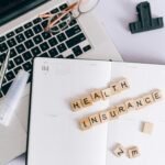 Health insurance form, stethoscope, and calculator used to compare medical coverage costs.