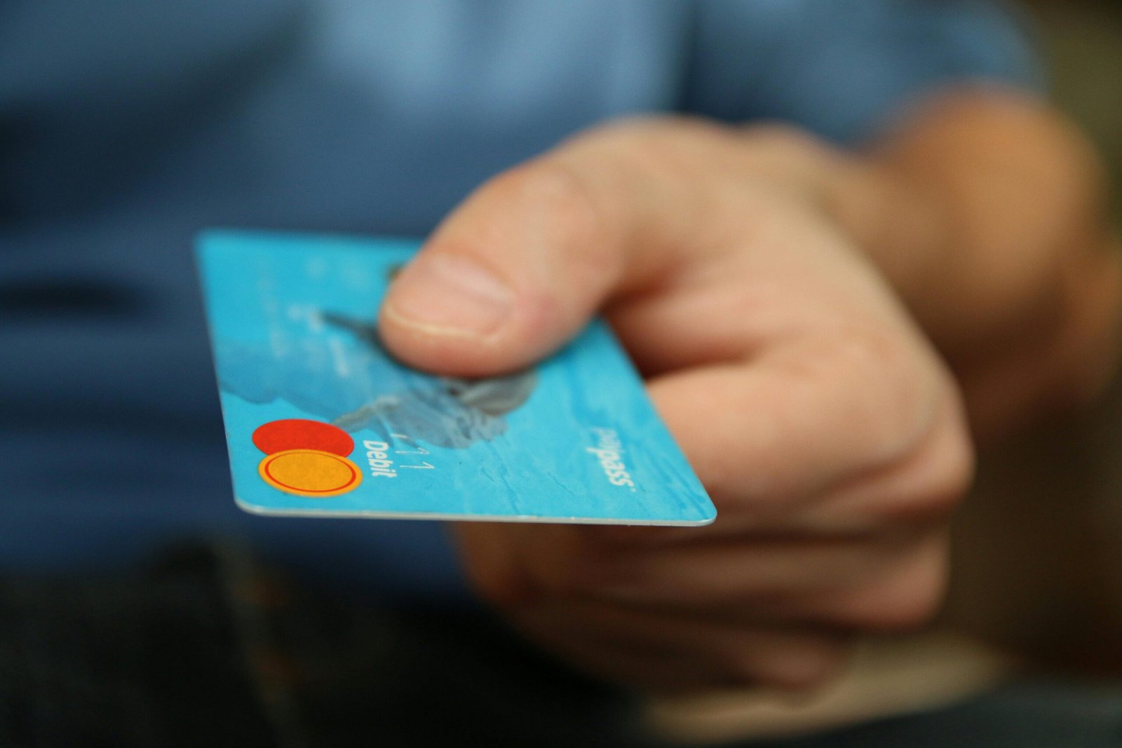Person using a debit card for secure online payment at checkout