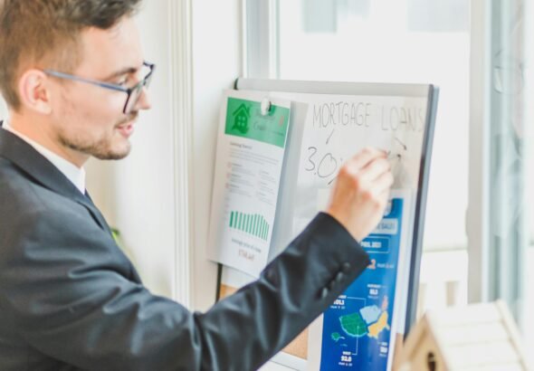Mortgage advisor explaining loan rates on a whiteboard during a home loan consultation.