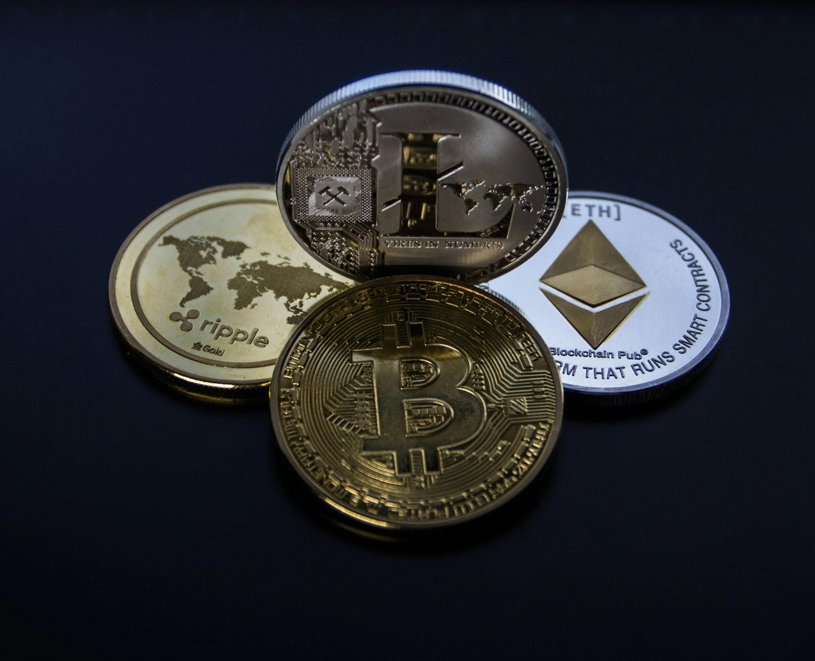 Collection of Bitcoin, Ethereum, Litecoin, and Ripple coins representing the global crypto market.