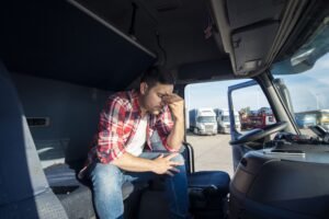 truck-driver-sitting-his-truck-cabin-feeling-worried-upset-min