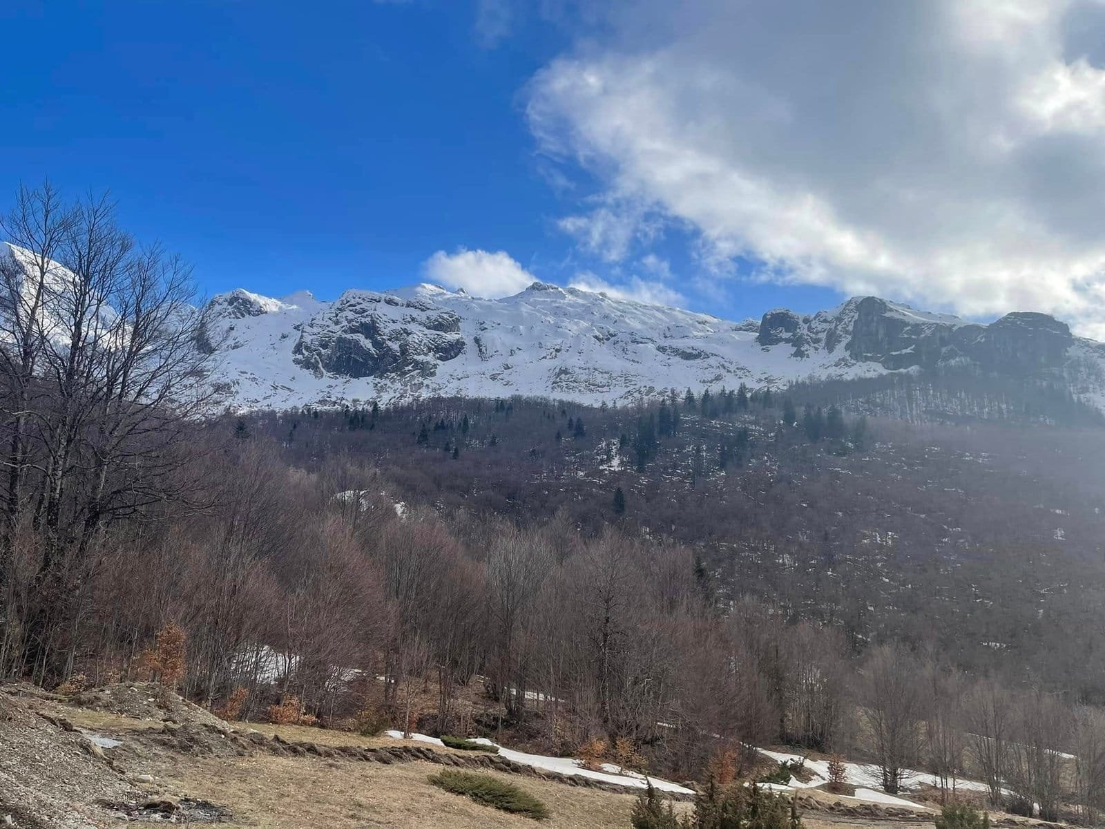 Hiking in Prokletije National Park near Vusanje with view of sharp alpine peaks and green valley